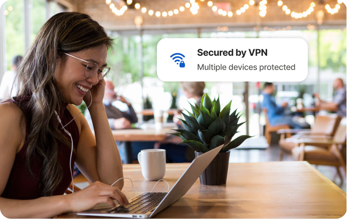 一名女子在咖啡廳對著筆電笑