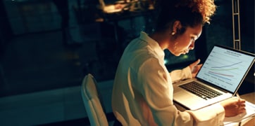 一名女子坐在筆記型電腦前